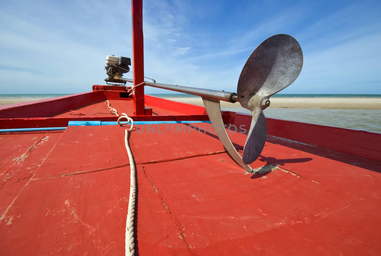 The propeller of red wooden fishing boat on the beach