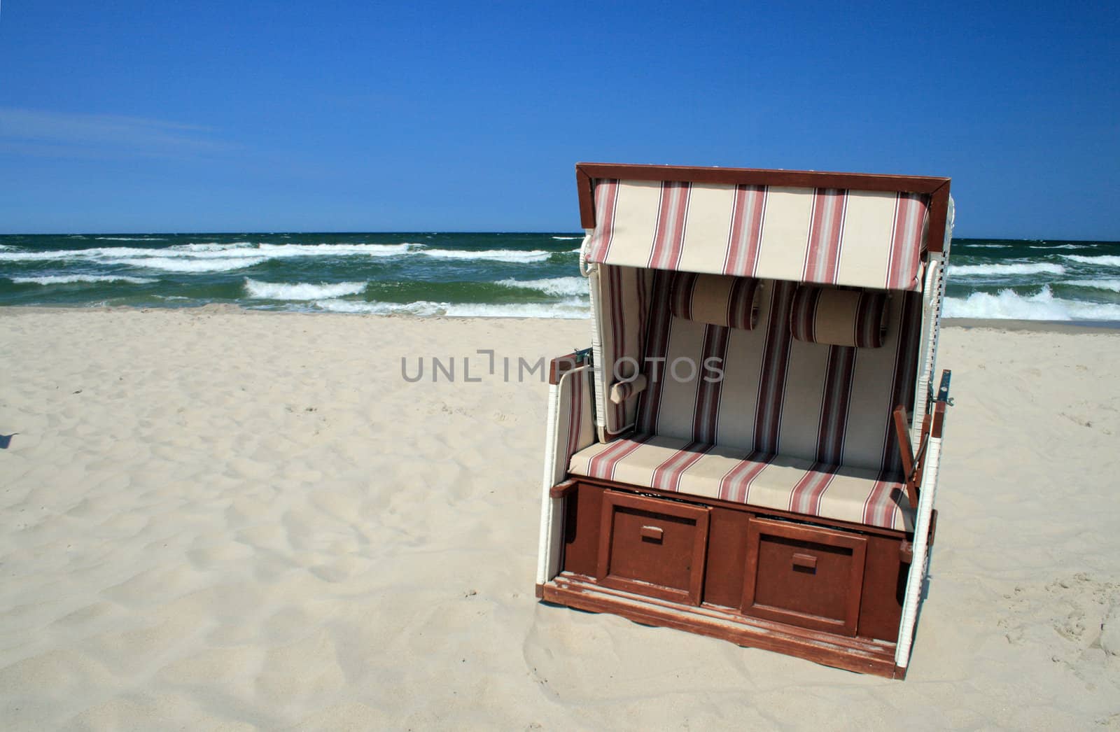 Wicker roofed beach chair standing at the beach
