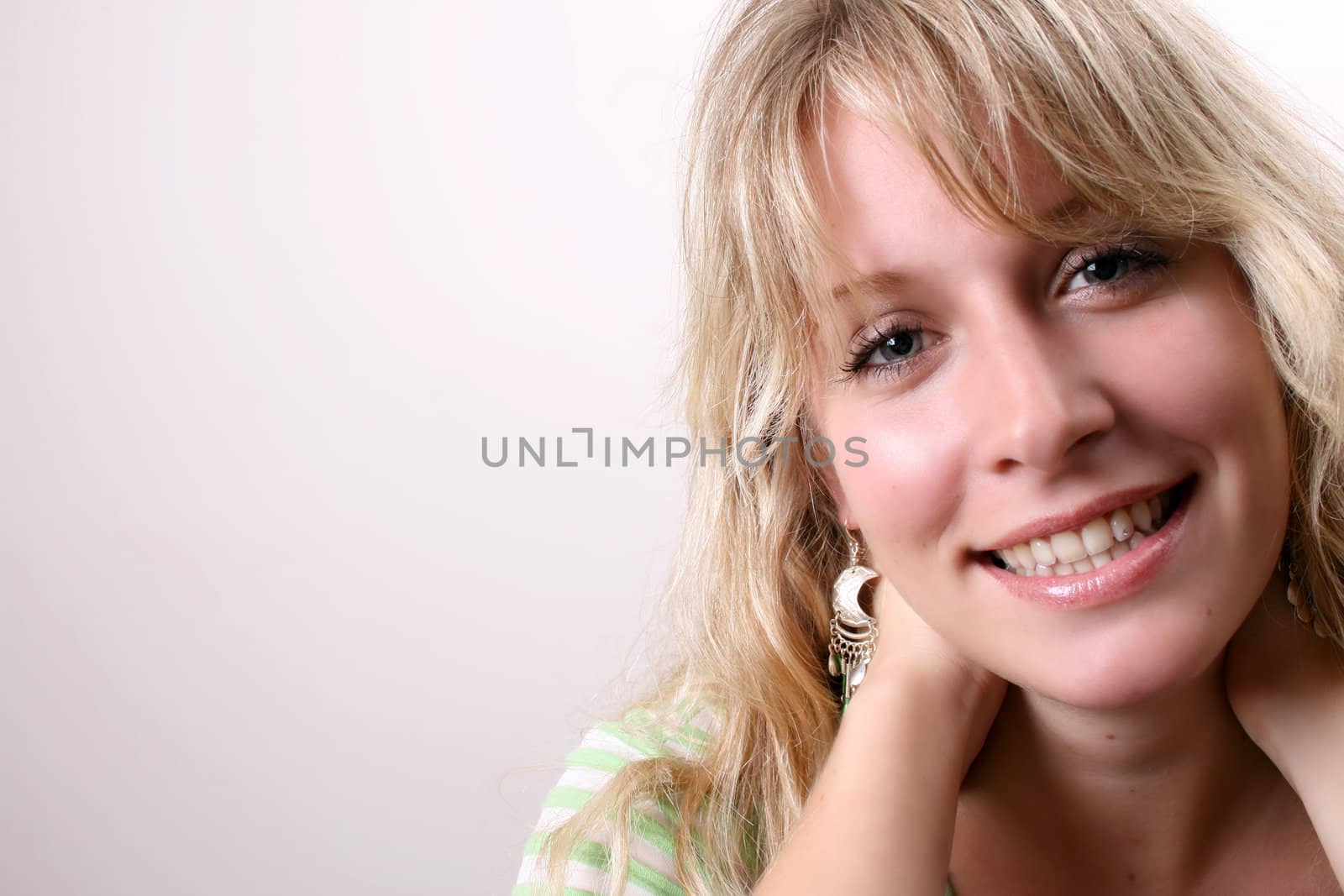 Blond Female model on a white background wearing a green top