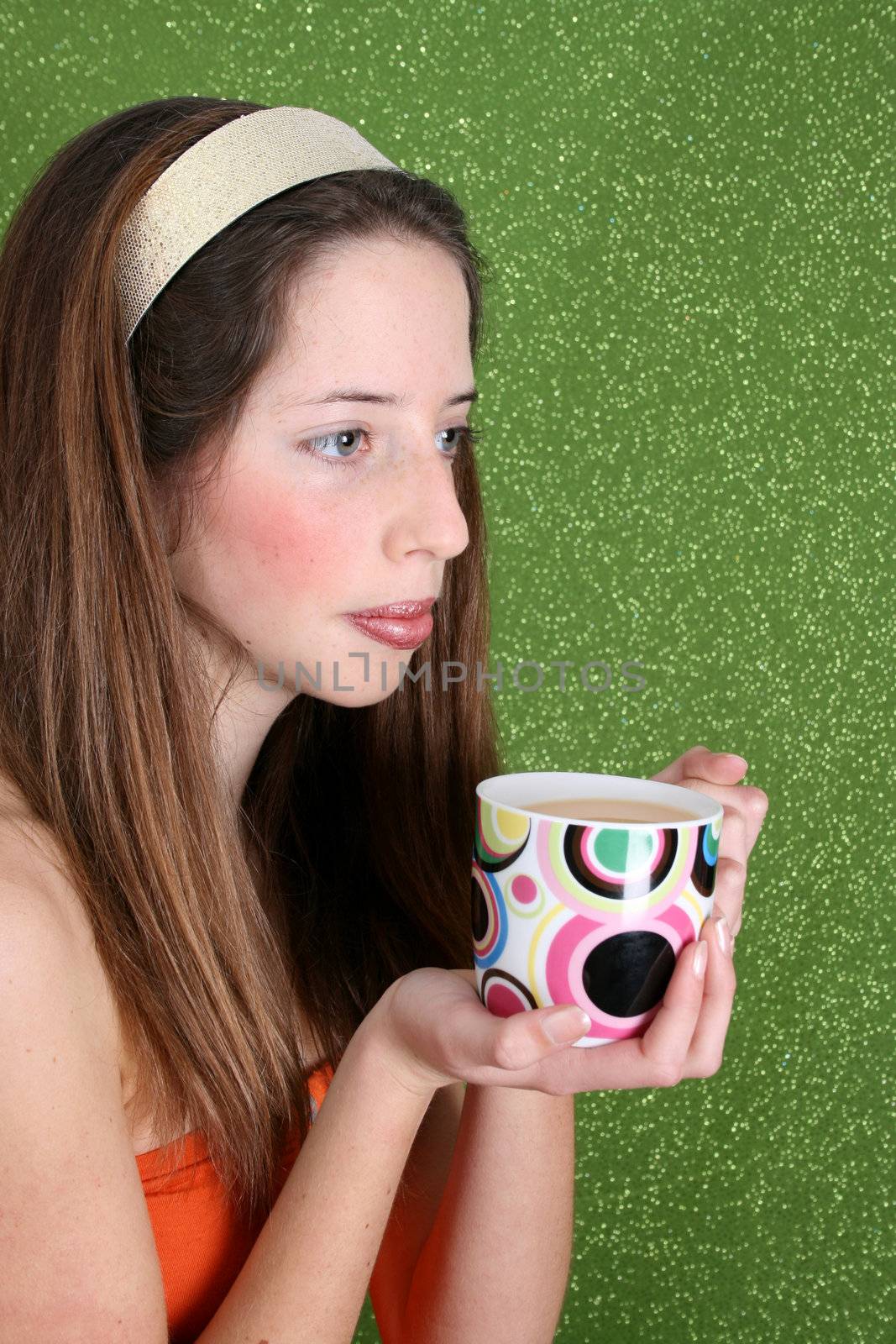 Brunette teenager on a green background wearing a broad head band