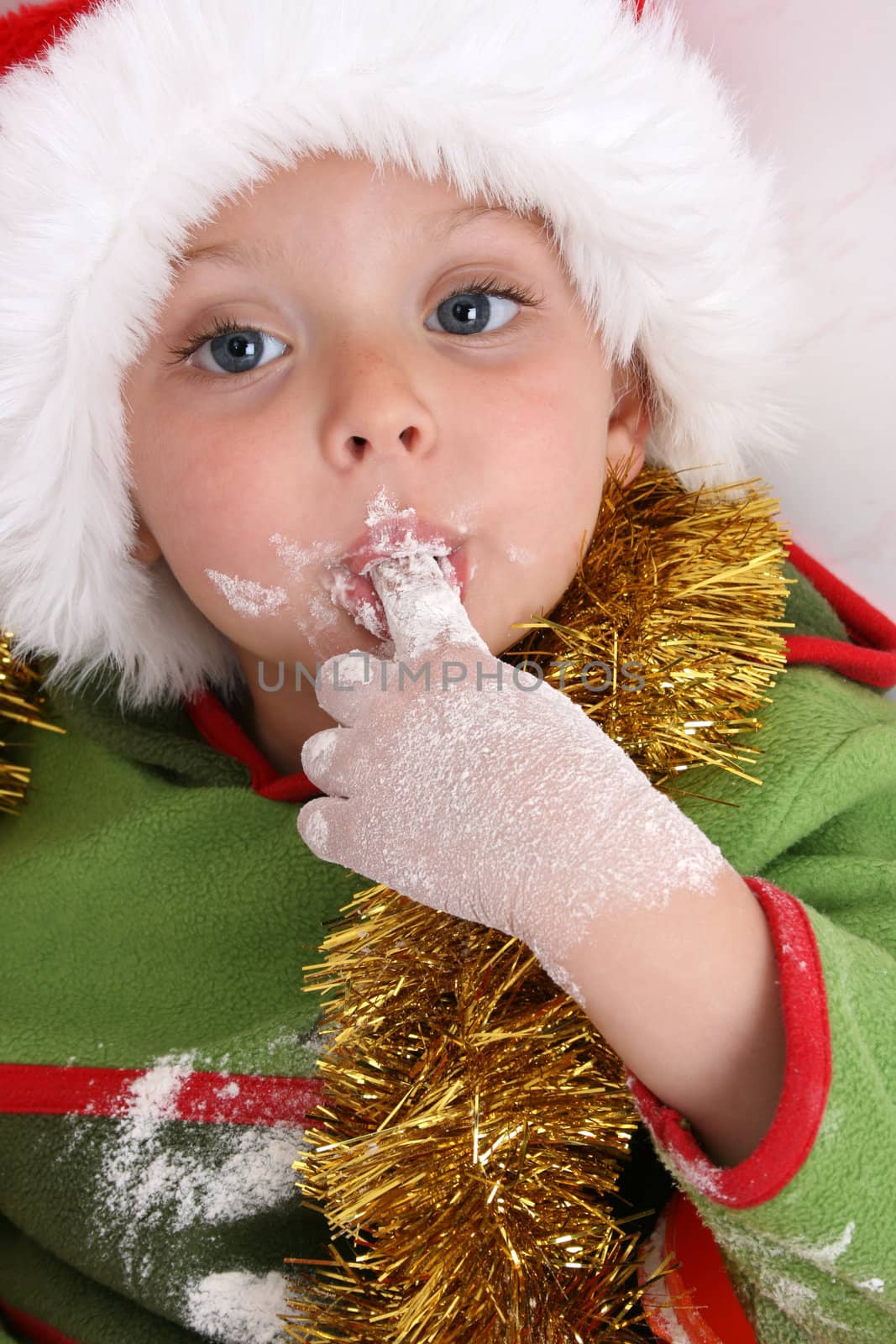 Toddler wearing a christmas hat, baking christmas cookies
