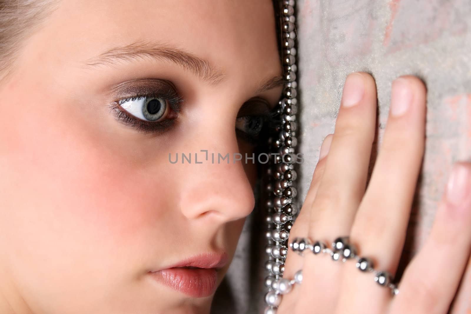 Beautiful model with blue eyes holding strings of beads