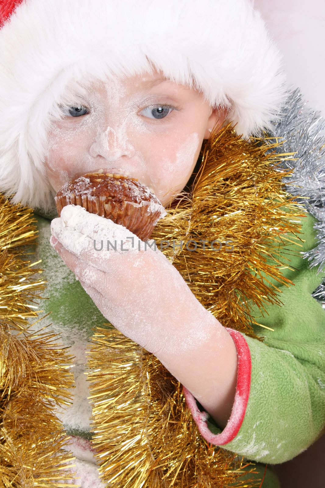 Toddler wearing a christmas hat, baking christmas cookies