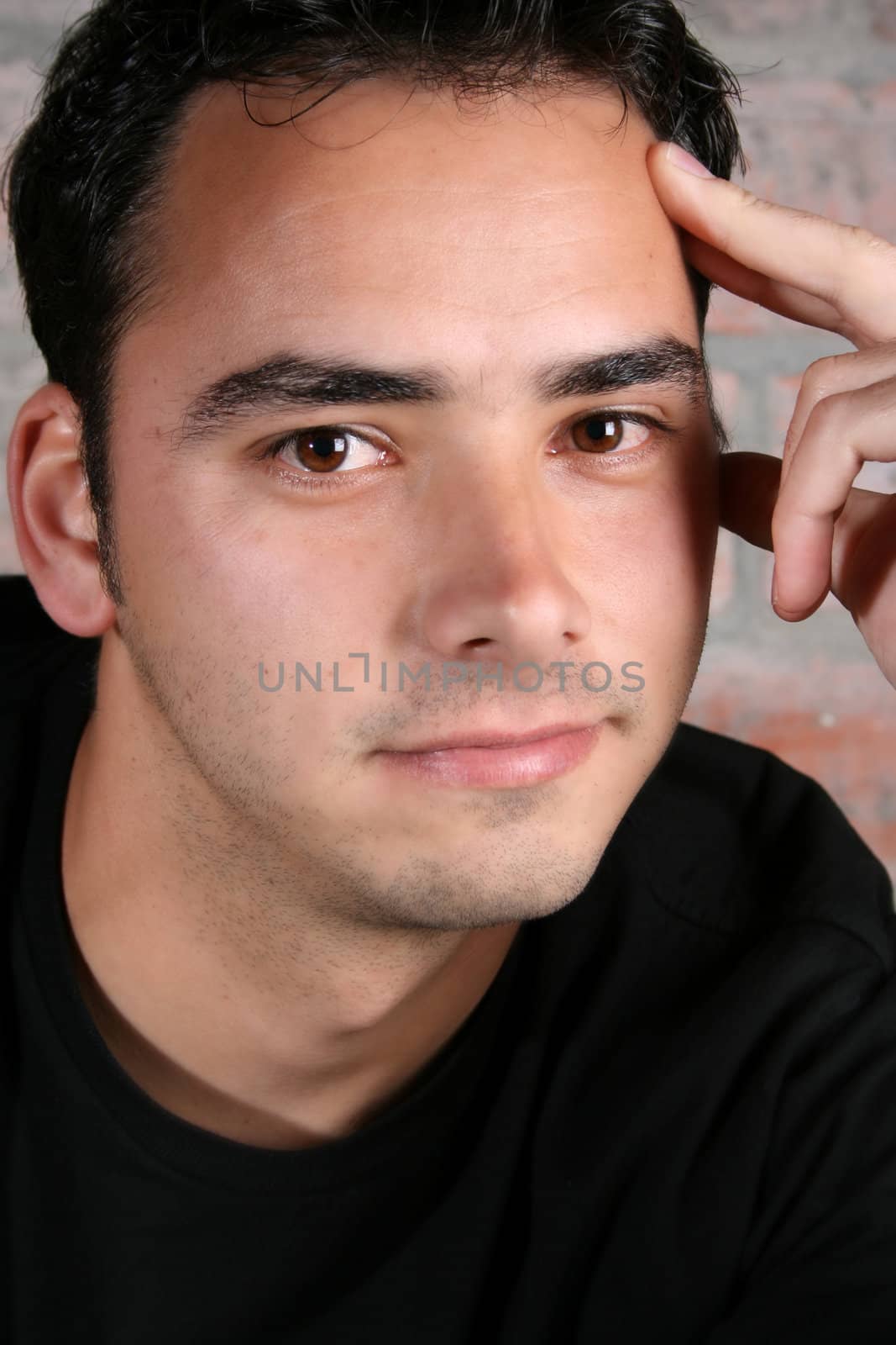 Male model against a rough brick wall background