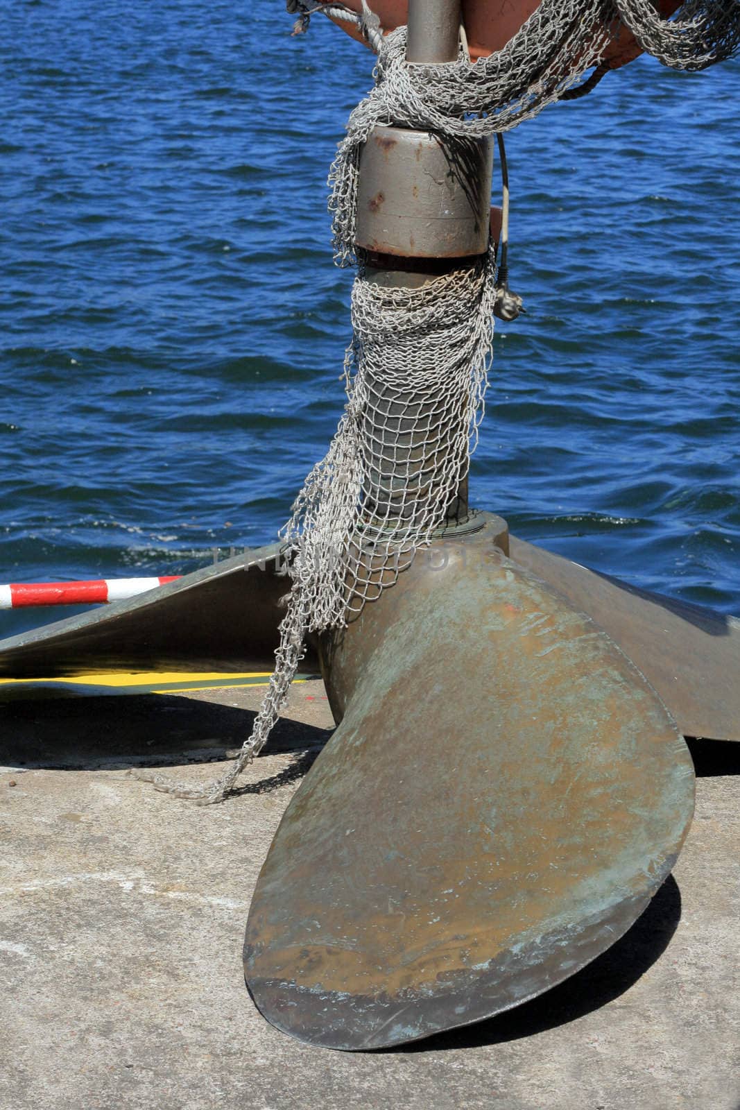 Steel vessel's proppeler with the nets laying on the quay
