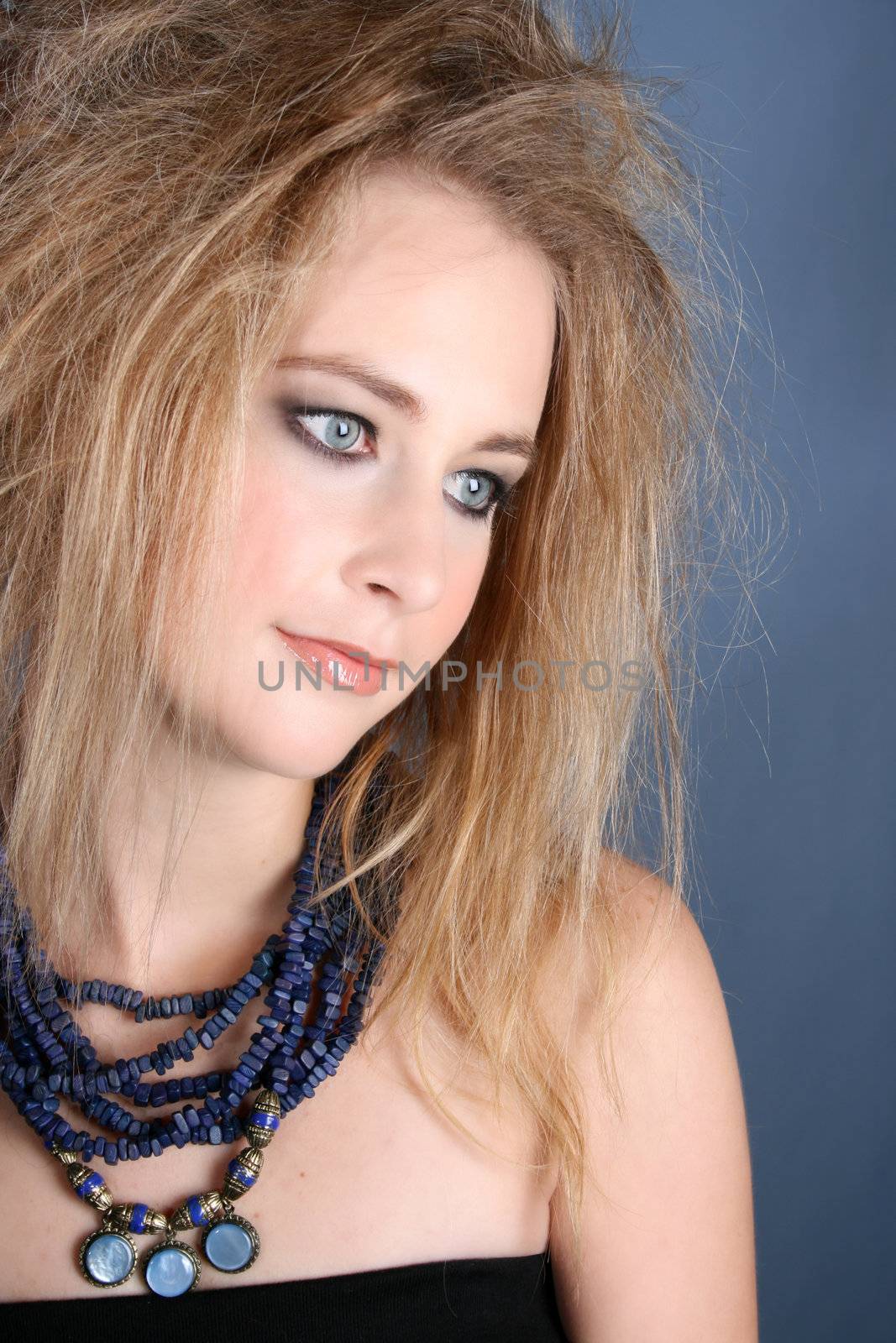 Beautiful female model with blue eyes against a blue backgroundl