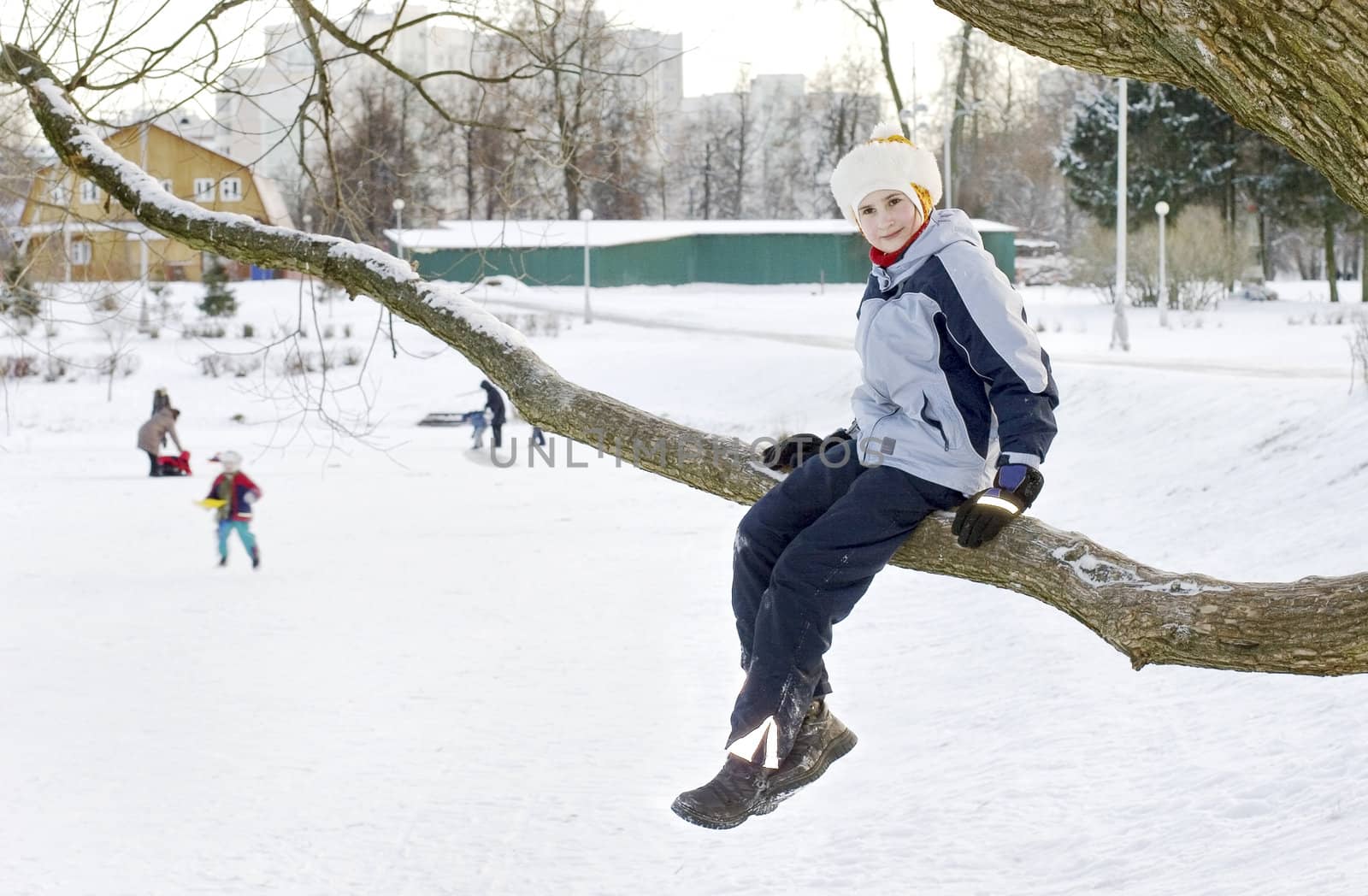 Girl in tree. Winter time, Russia. Playng children. 