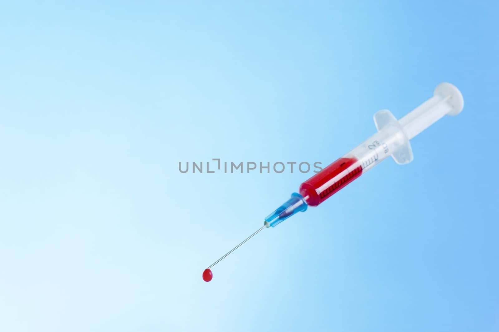 syringe with fresh blood. One drop on needle-point.