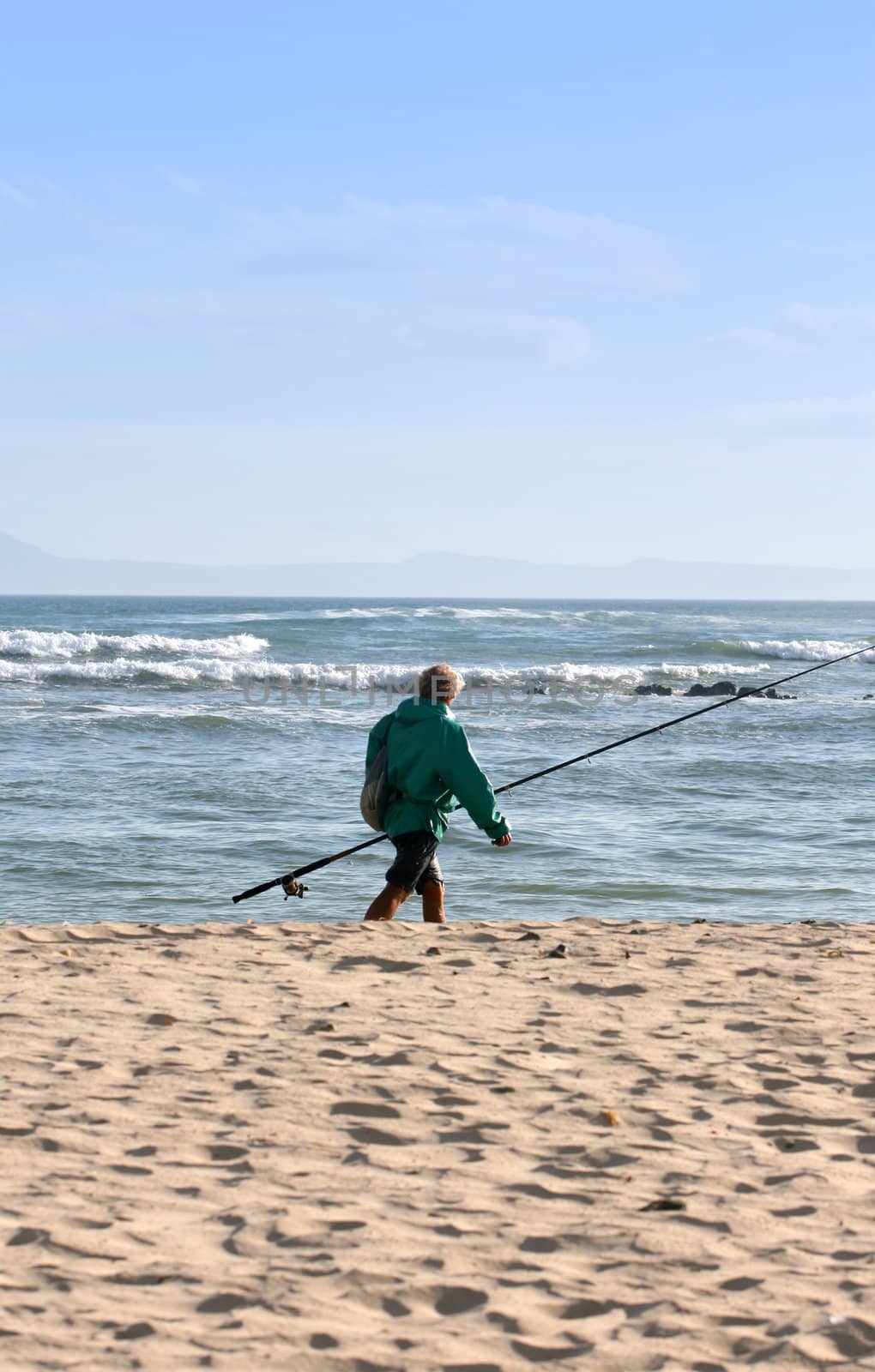 Fisherman walking on the beach after a days fishing