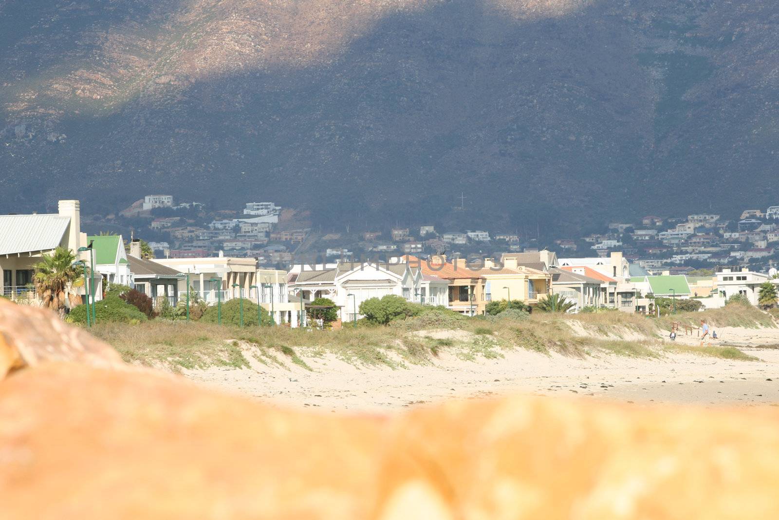 Houses on beach front, with rocks in forefront