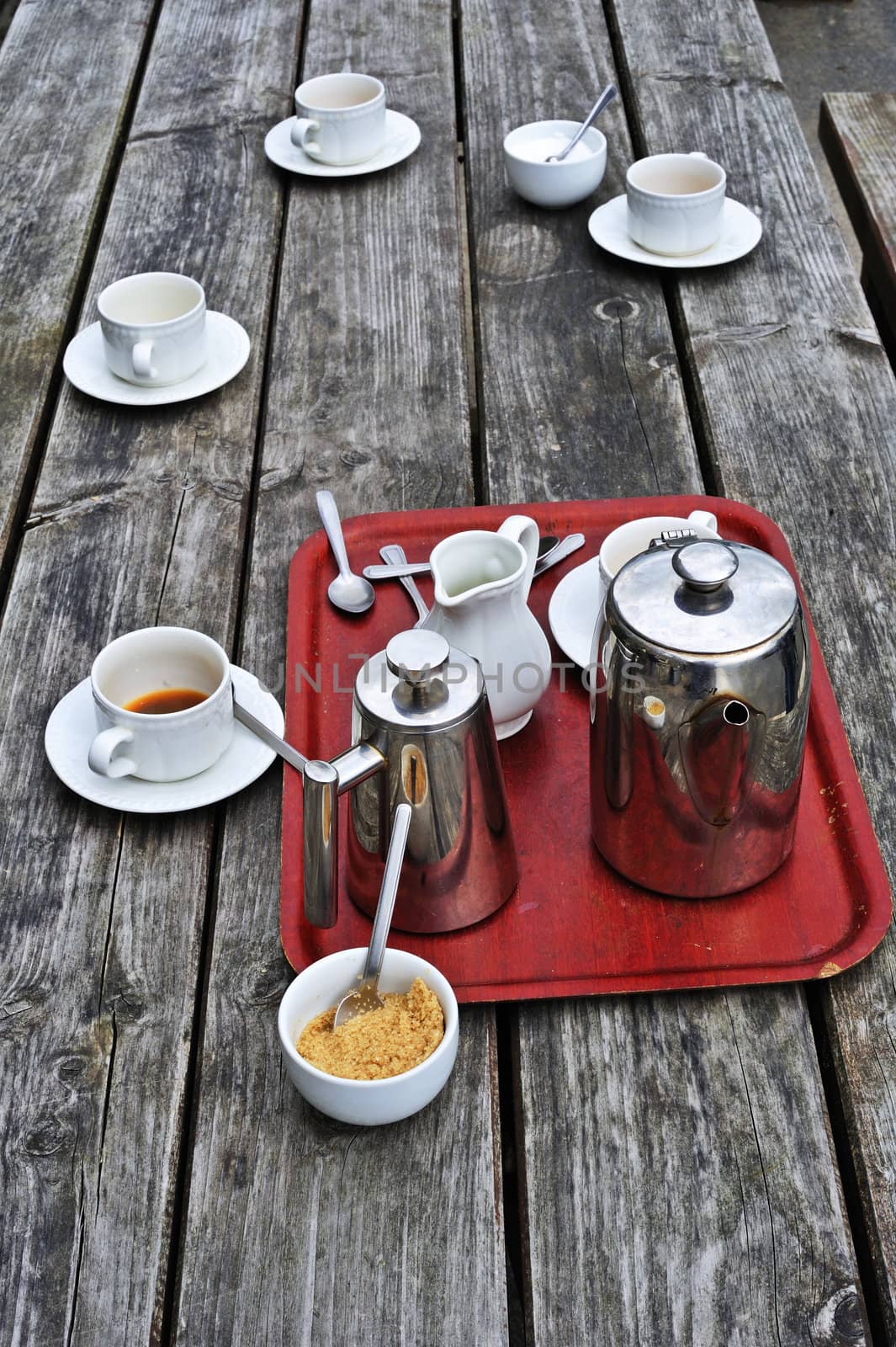 Empty cups on a wooden table, after a pot of tea has been drunk at an outdoor cafe