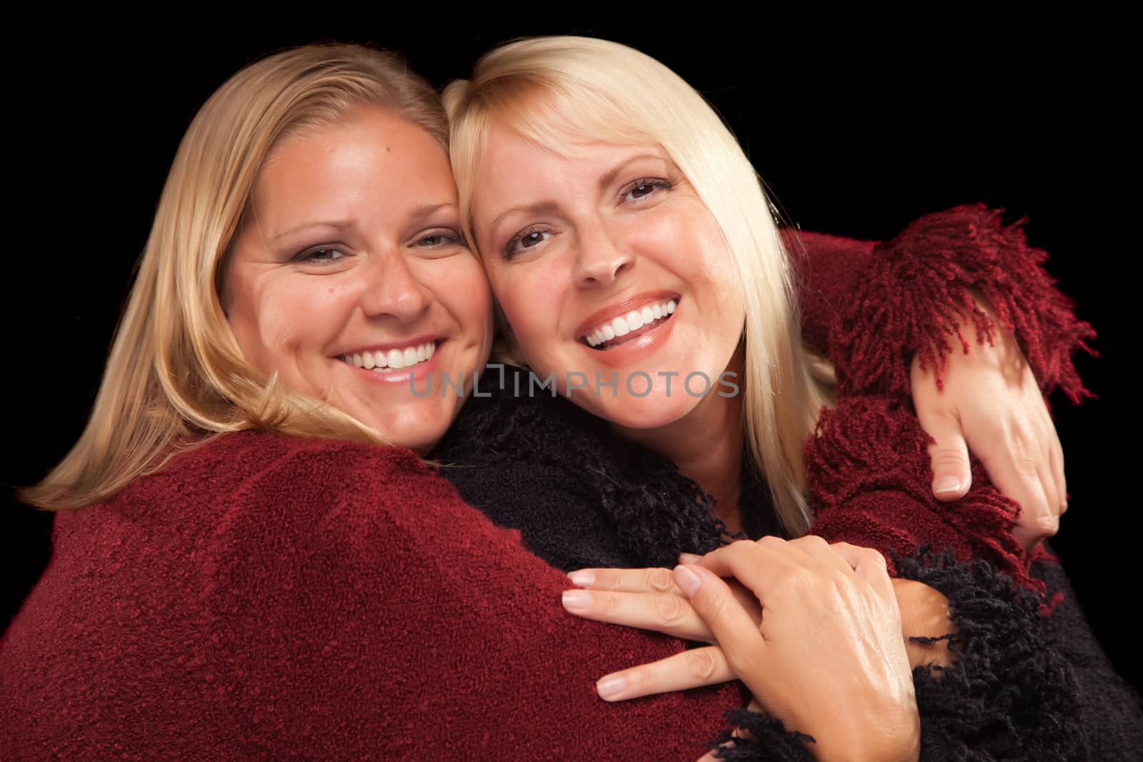 Two Beautiful Smiling Sisters Portrait Isolated on a Black Background.