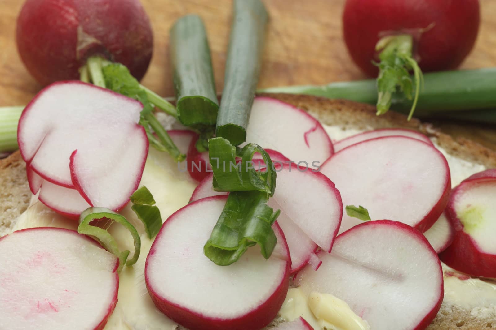 Fresh radish bread with spring leek as background