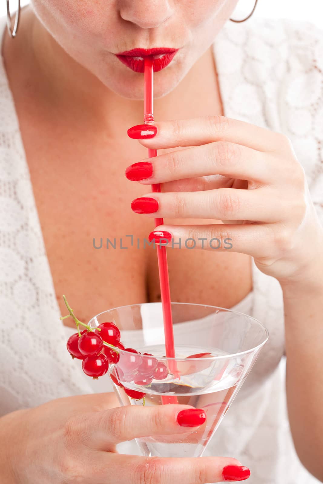 Pretty woman drinking out of her cocktailglass with a red straw