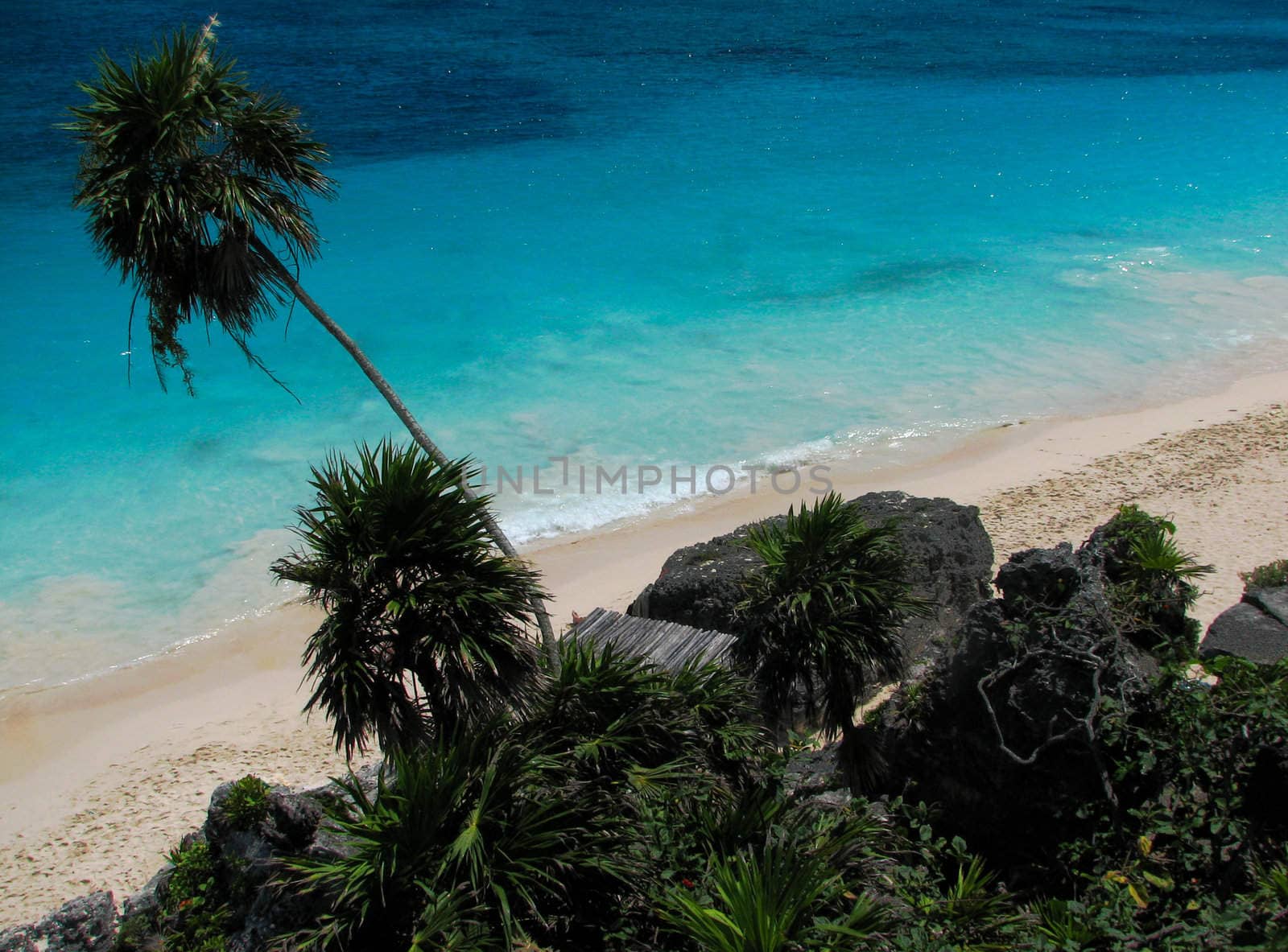 A beach scene with blue heaven, clouds and turquoise water