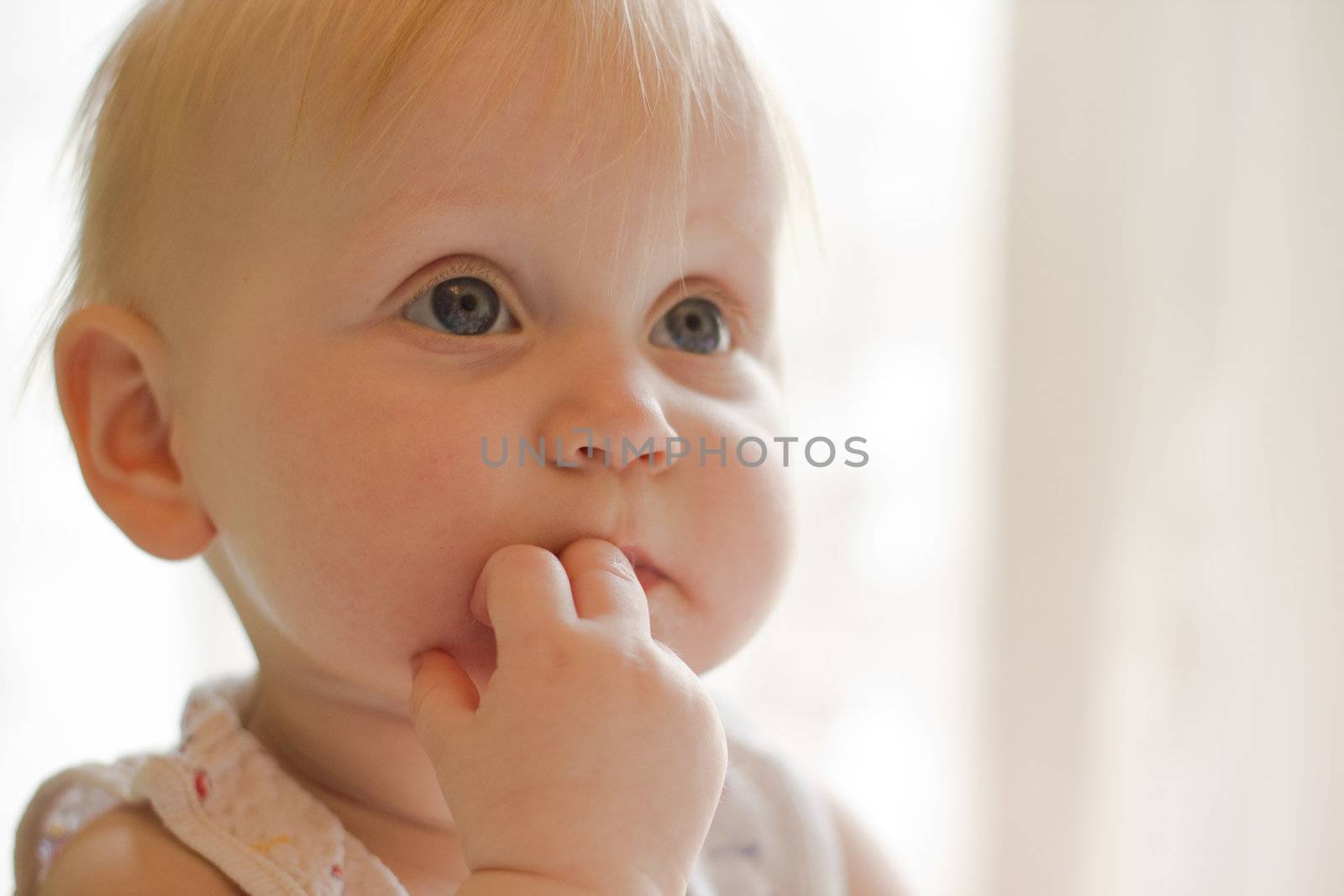 Portret of little  girl with fingers in a mouth
