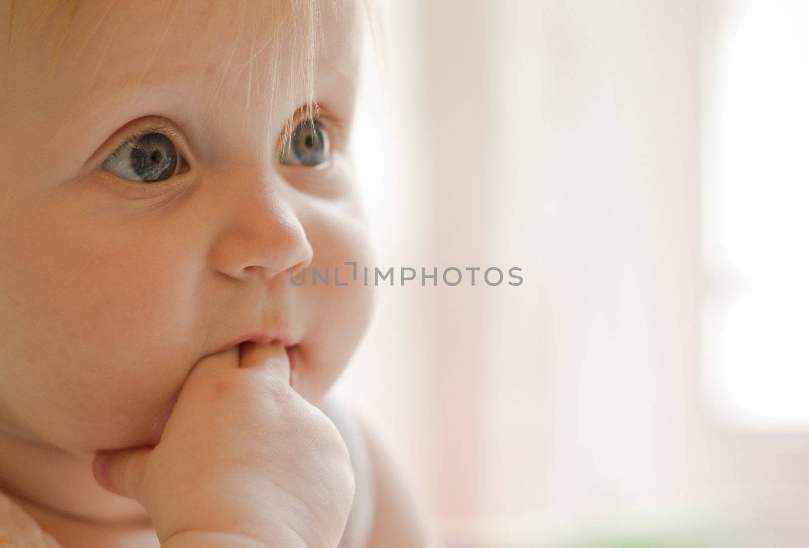 Portret of little  girl with fingers in a mouth