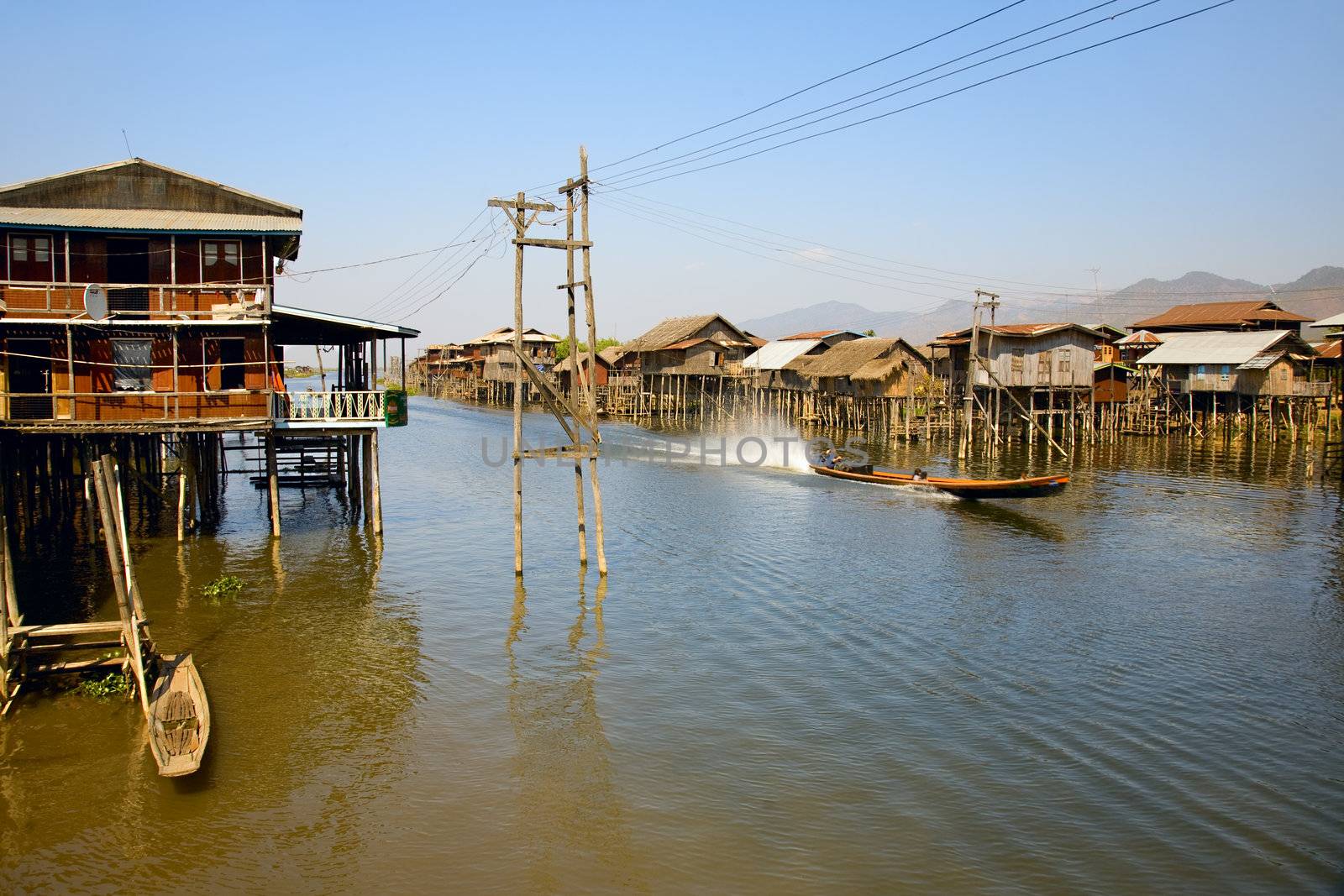 Village house on Inle lake standing on stilt and made from bamboo and palm leafs is accessible only via small boat.