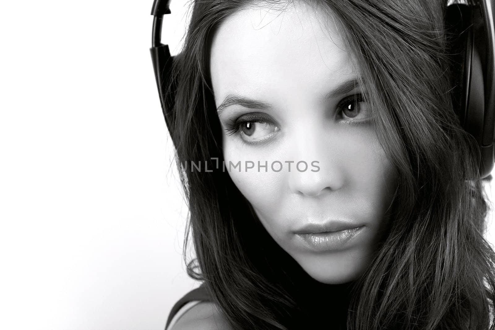 Pretty young woman in earphones closely in monochrome