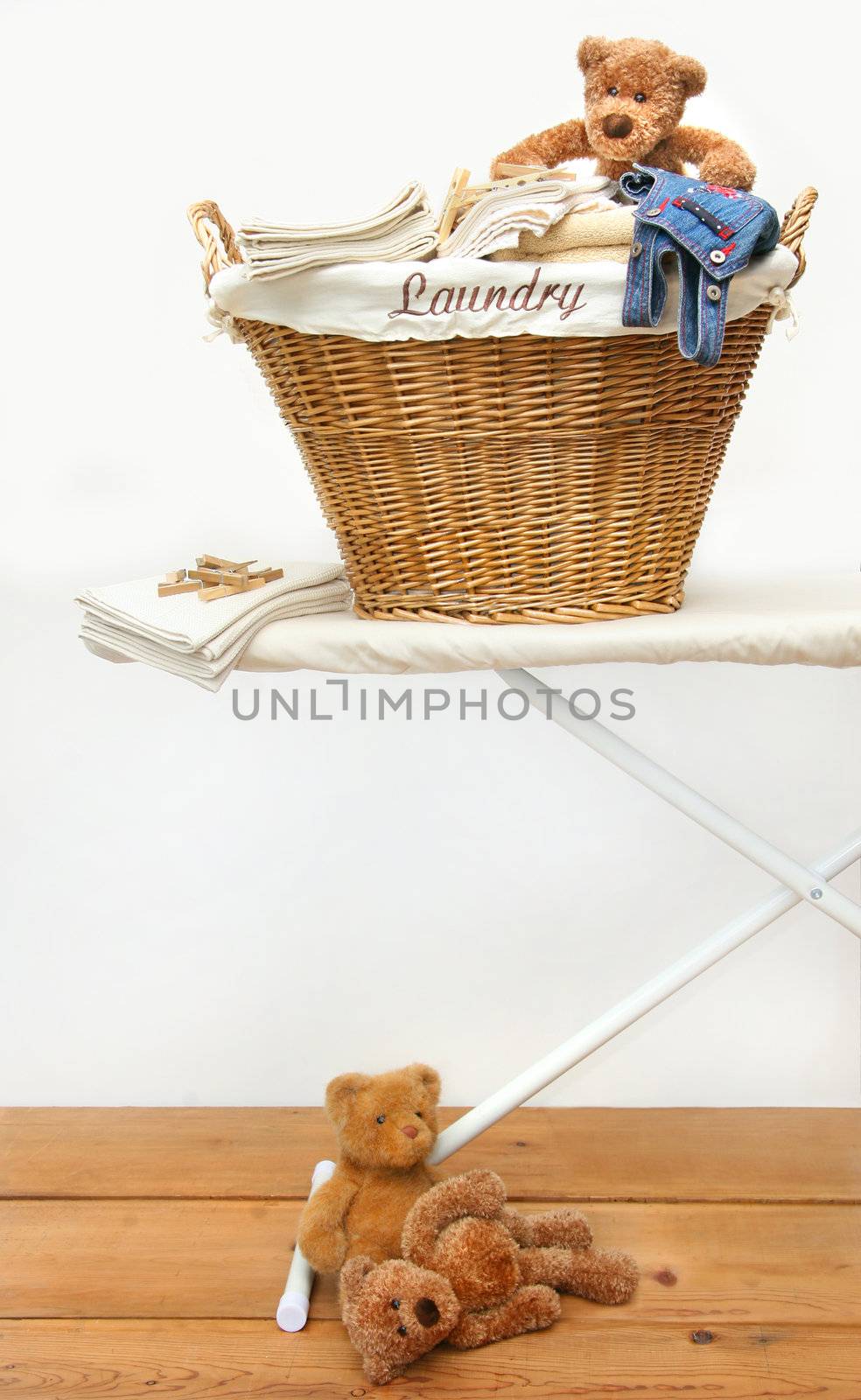 Laundry basket with teddy bears on pine floor