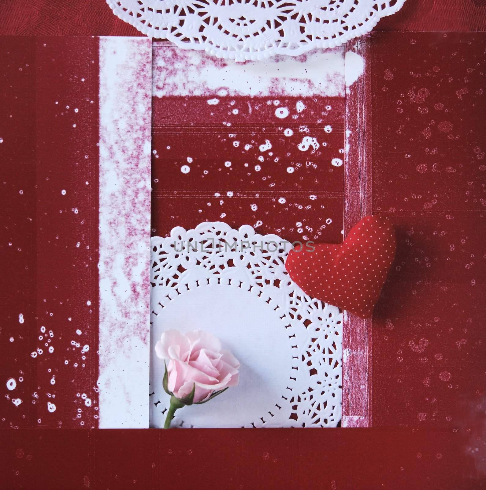 a pink rose and a fabric heart with doilies on a red spotty background
