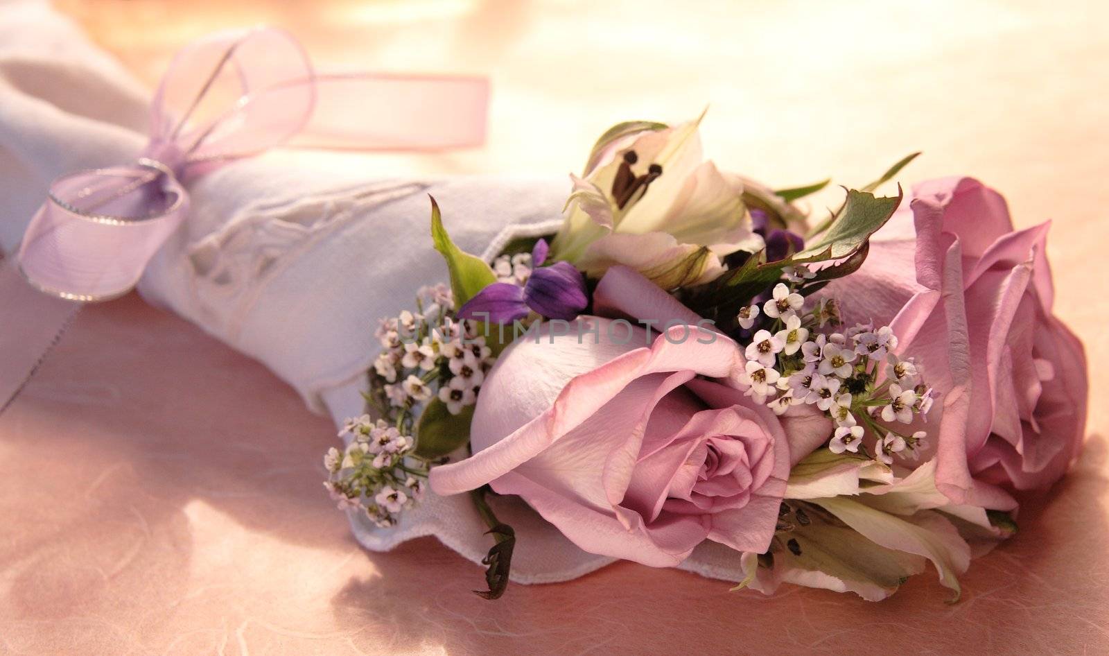 bouquet of roses, alstroemeria, alyssum and violets tied with a lavender ribbon