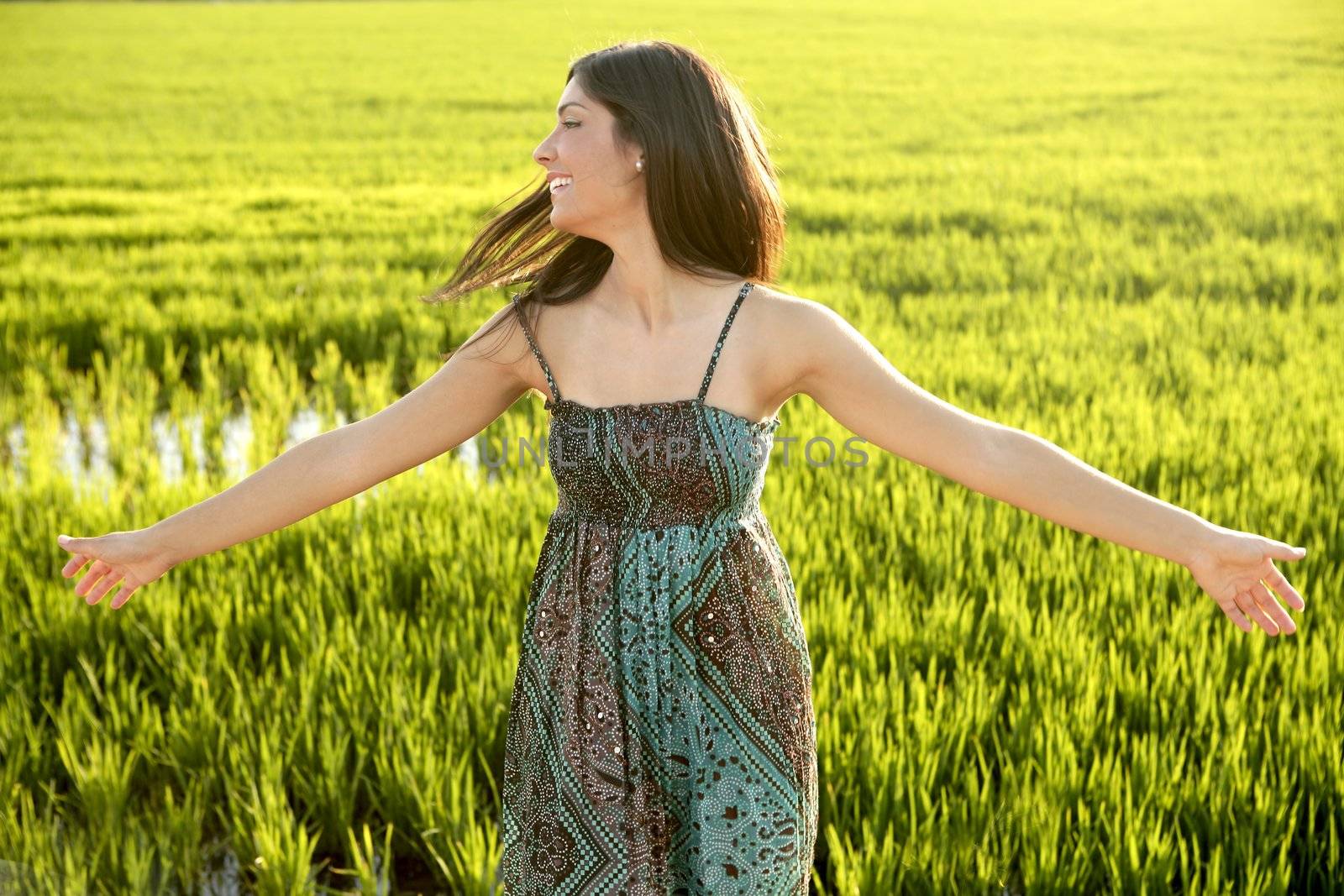 Beautiful brunette indian young woman in the green rice fields meadow