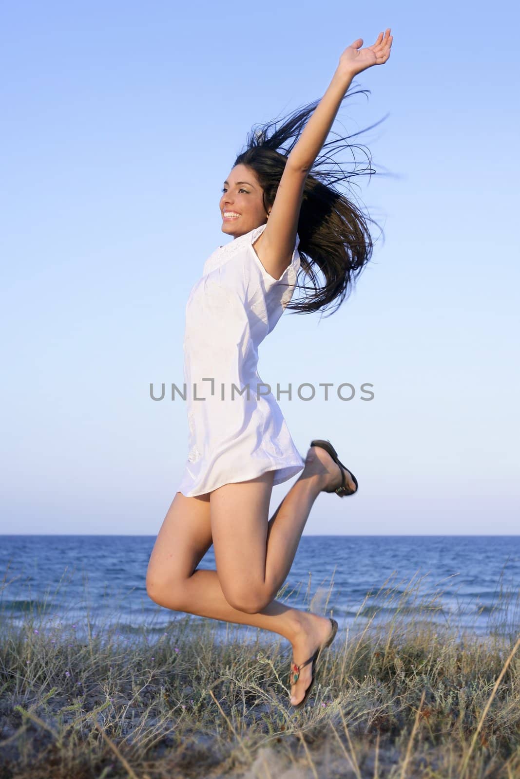 Beautiful brunette jumping in the beach by lunamarina