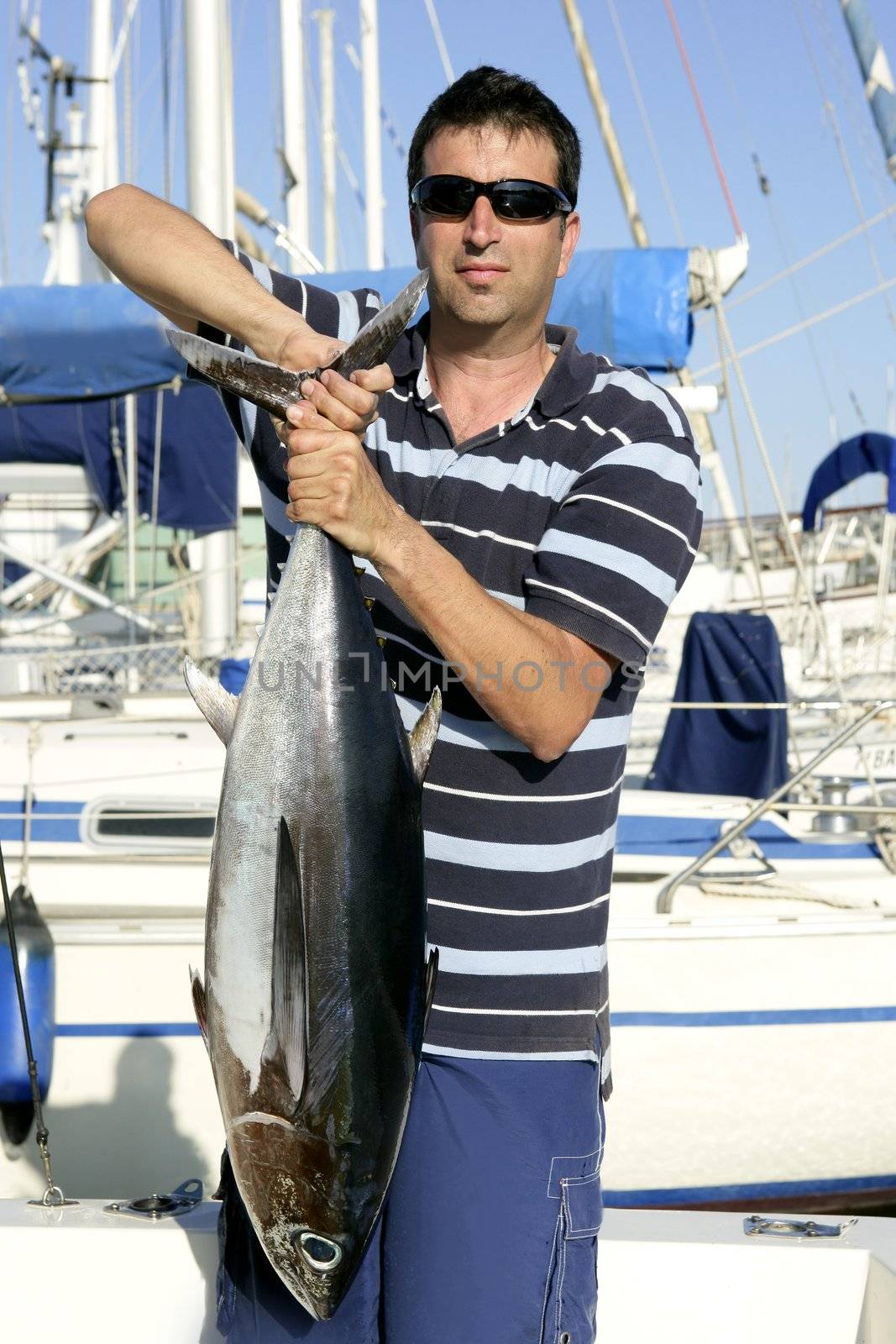Big game fisherman with saltwater tuna catch in his hands