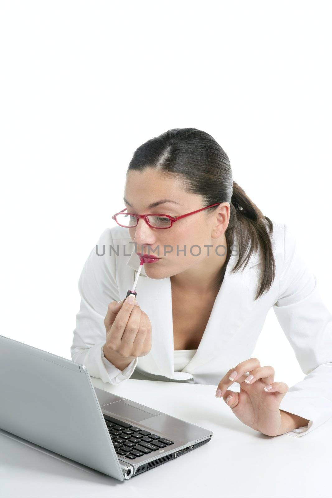 Business woman with red lipstick using laptop screen as a mirror