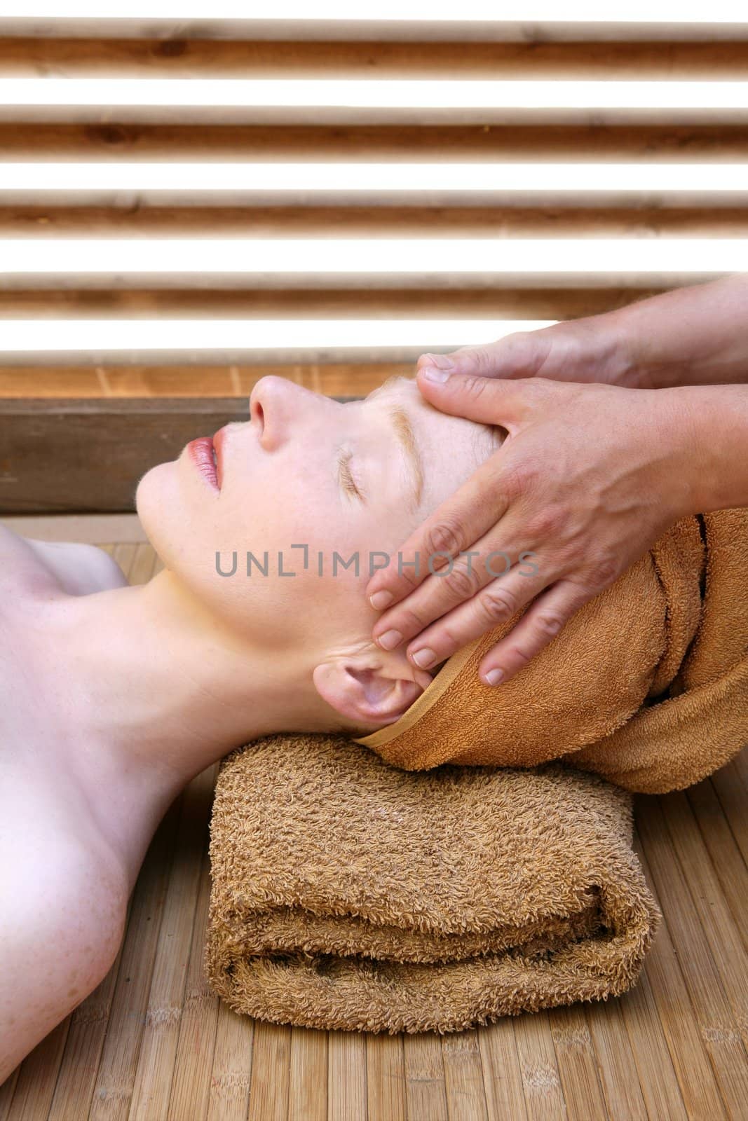 Beautiful woman portrait relaxing massage on her head in warm colors