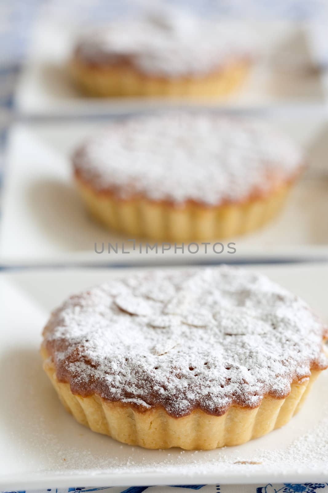 Freshly baked bakewell tarts in a row