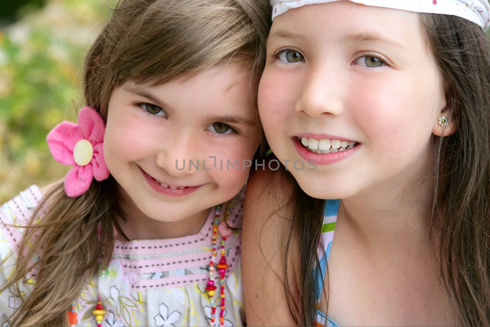closeup portrait of two little happy beautiful girl sisters