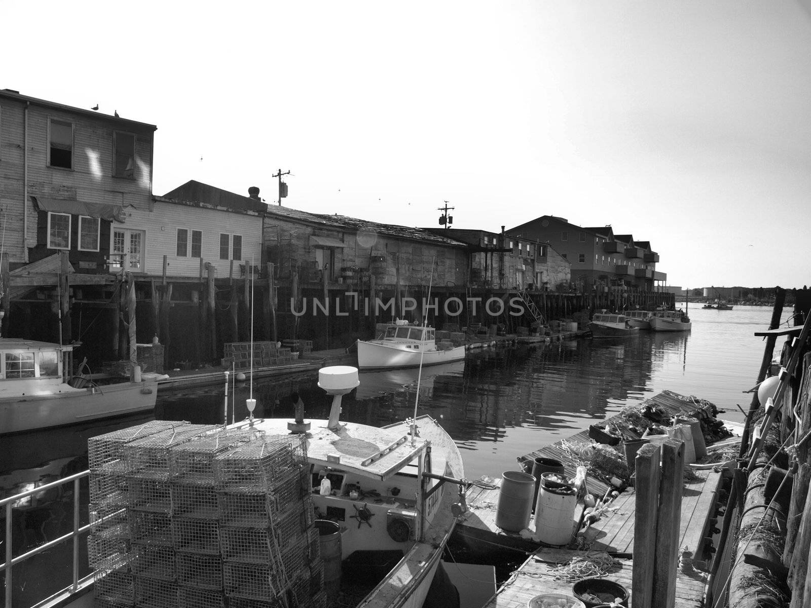A working lobster boat along the dock in Portland, Maine during the summer. Shown in black and white