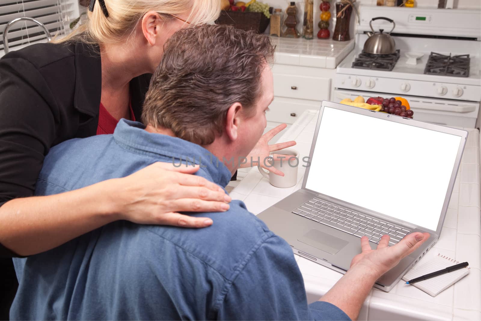 Couple In Kitchen Using Laptop with Blank Screen. Screen can be easily used for your own message or picture.