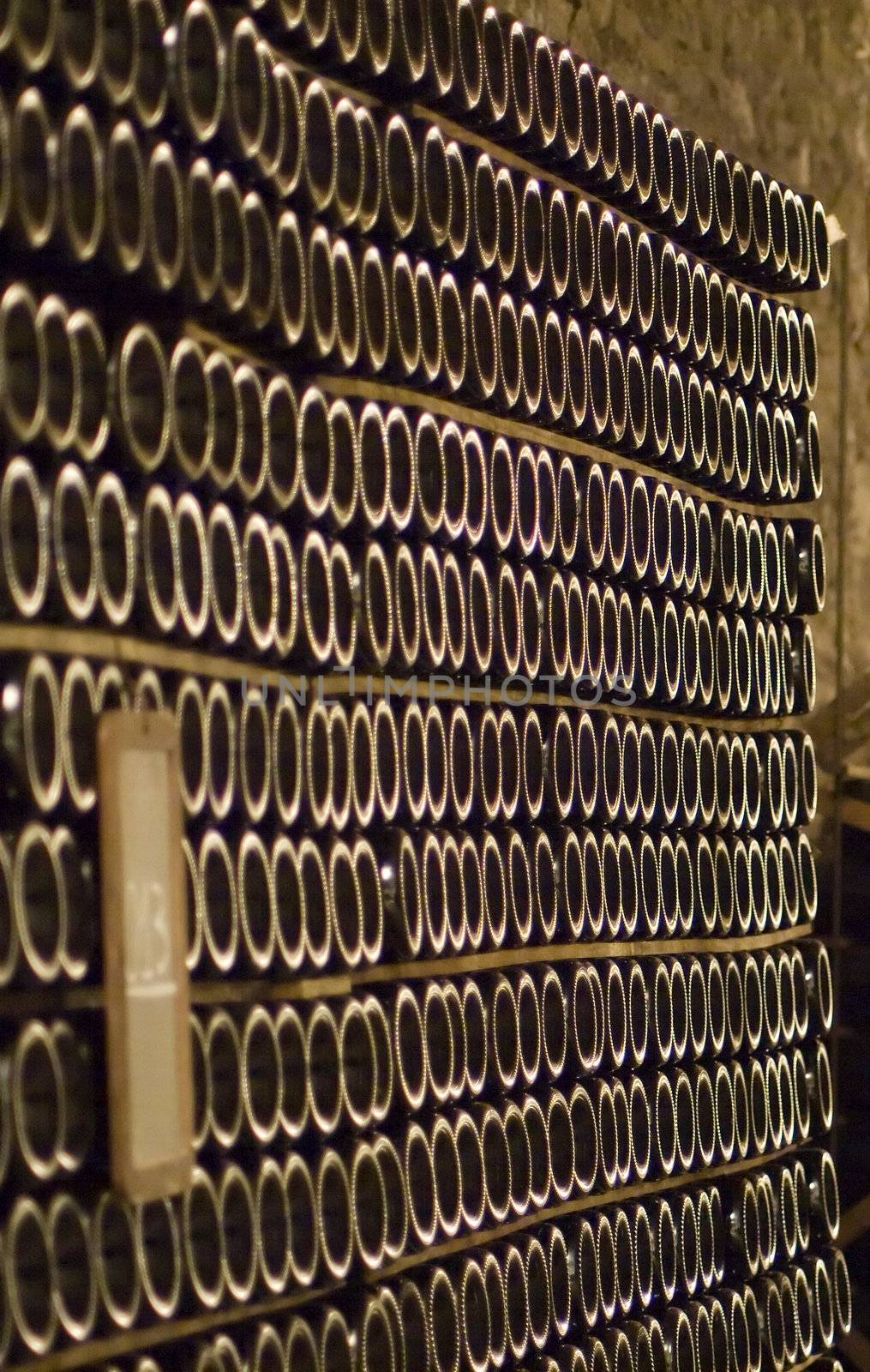 Closeup of bottles of wine aging in an old cellar