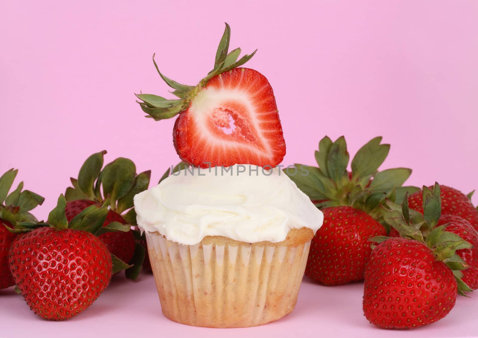 cupcake with white icing and strawberries