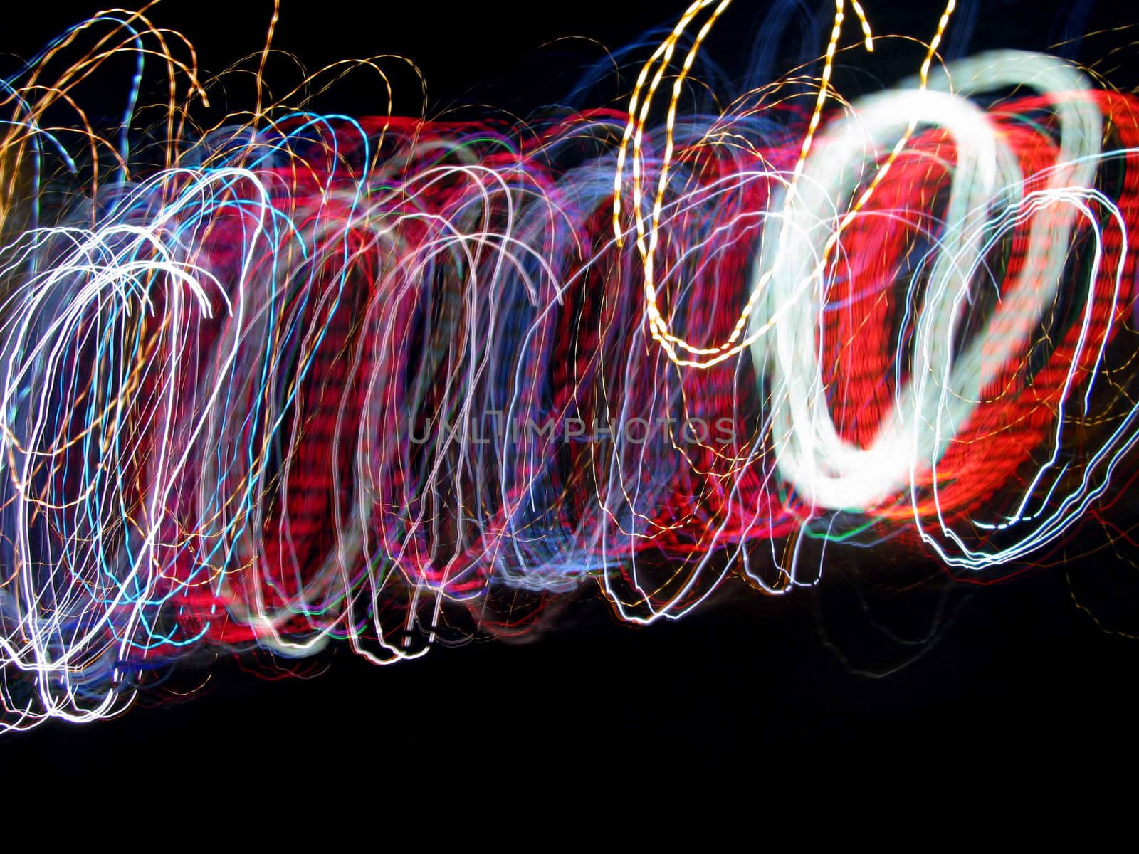 Swirls of Light Abstract Background looks like coils of wire or bracelets on a black background with copy space.

