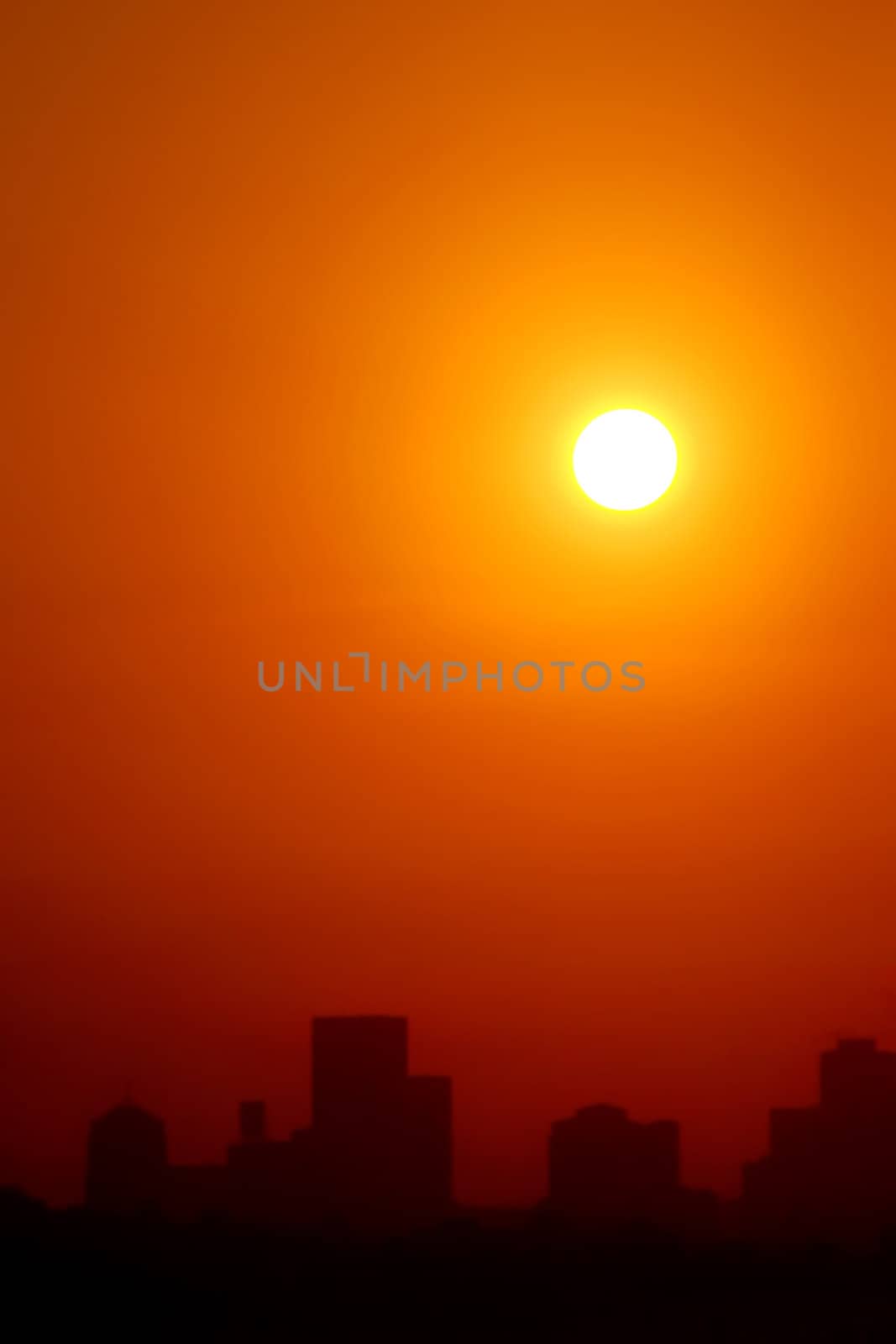 Burning sun seen hazily above an urban landscape