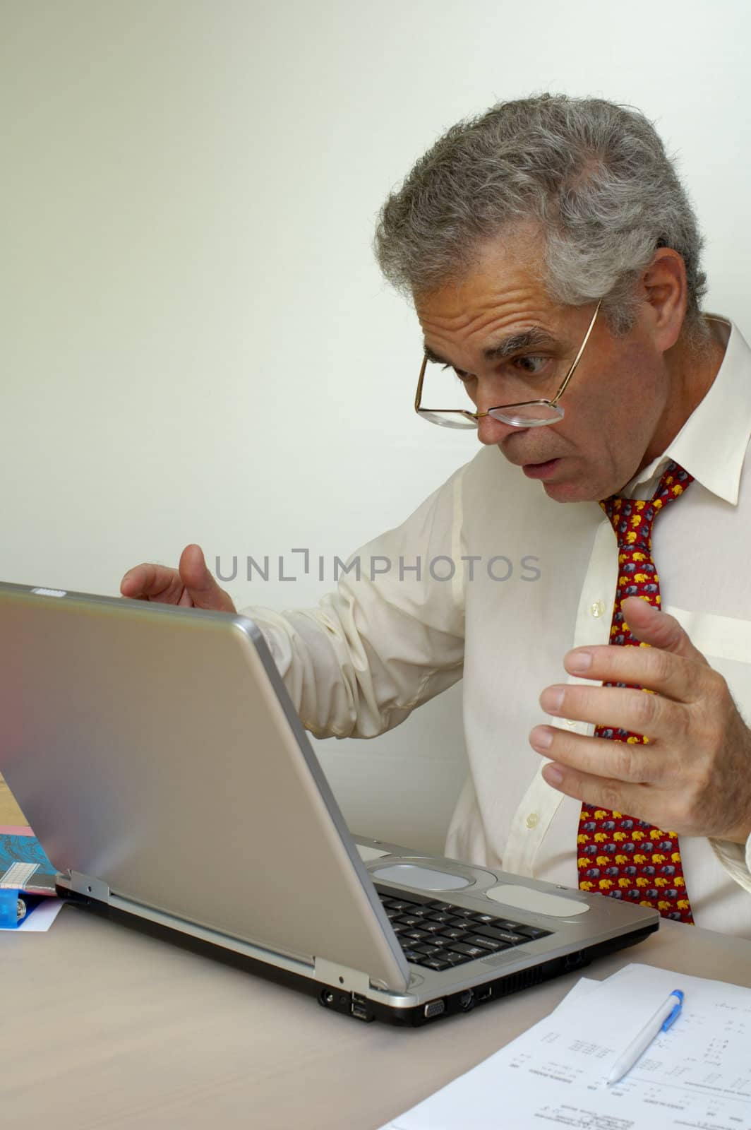 A businessman recoils from his laptop computer in horror. What's it doing now? Space for text on the white background.