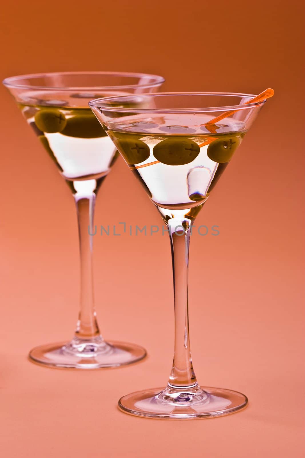two bocal of martini with olive over orange
