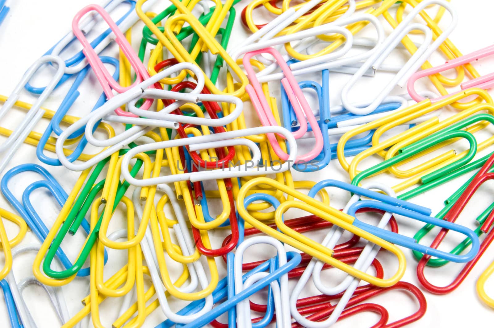 coloured paperclips background isolated on white