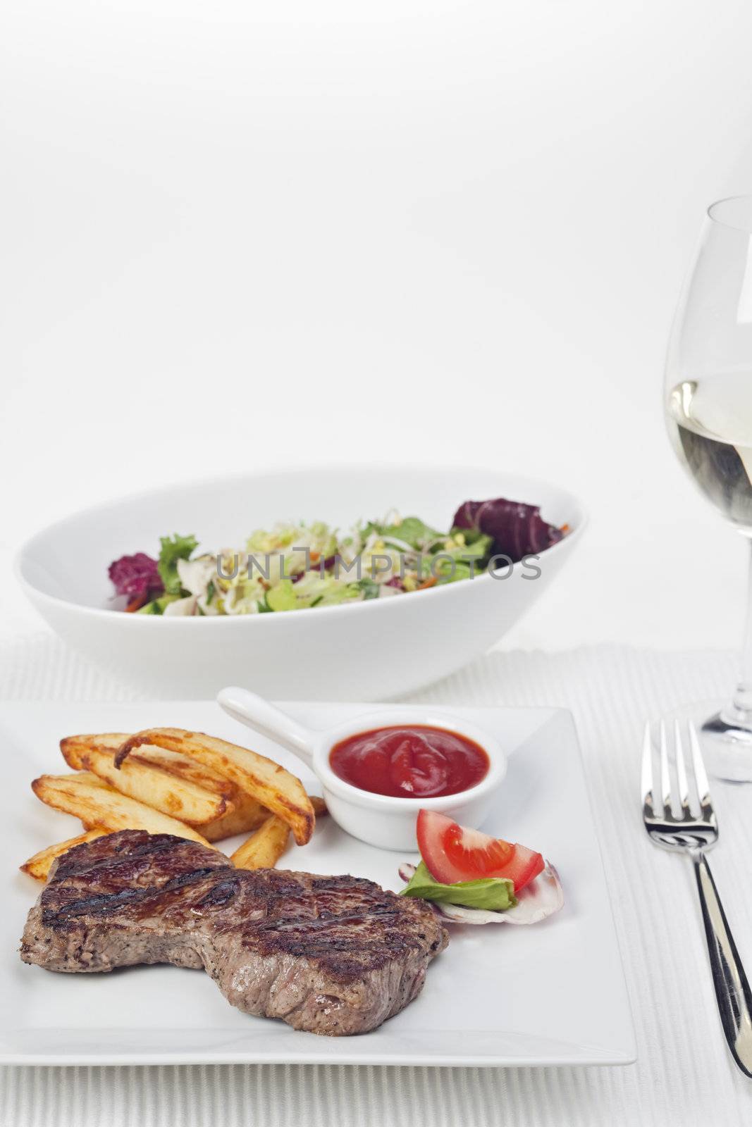 steak and french fries on a plate by bernjuer