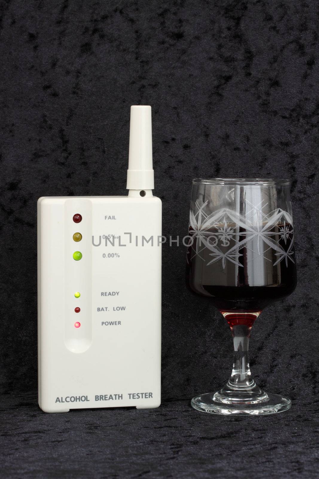 alcohol breath tester and glass of wine