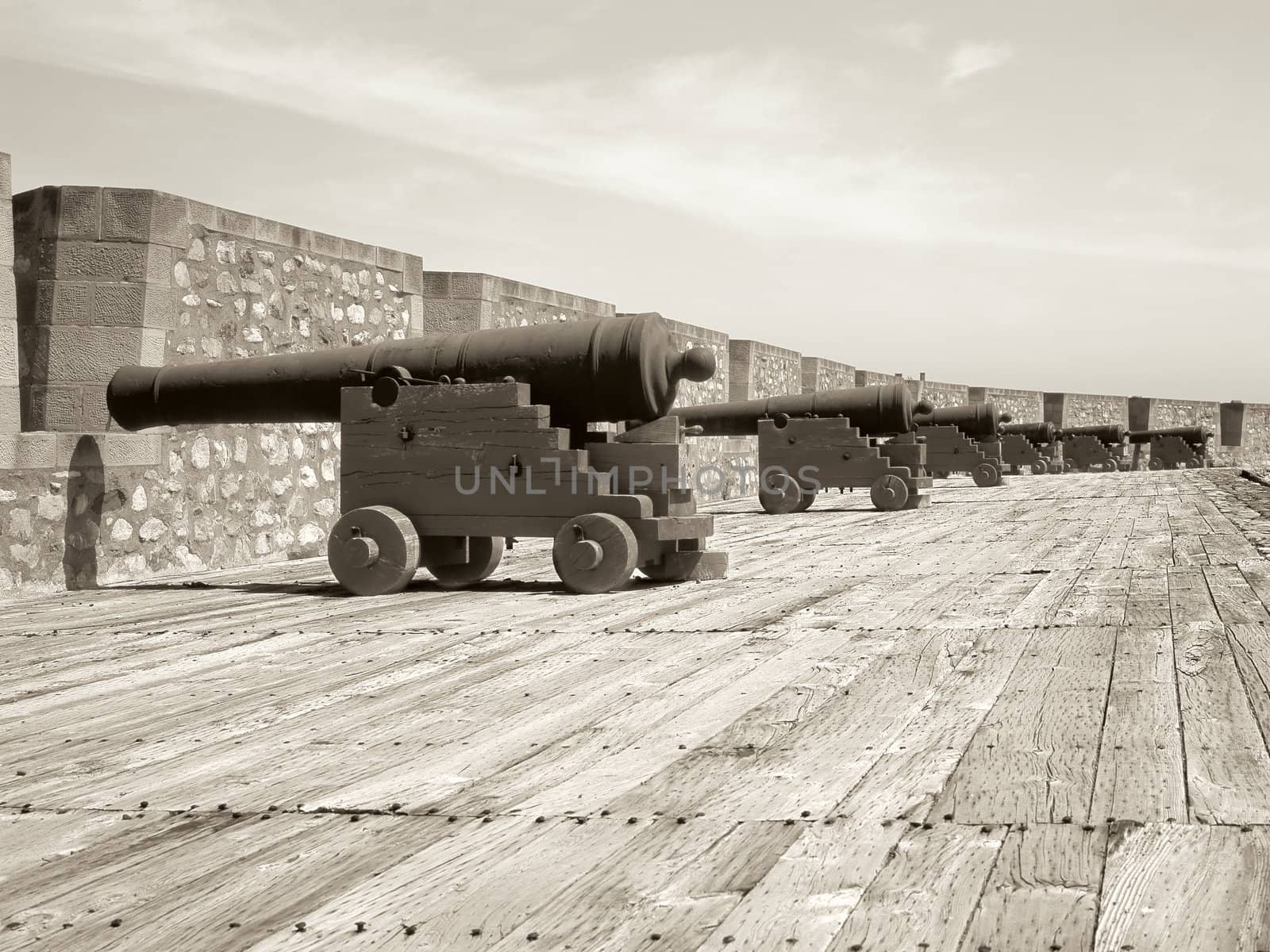 Sepia image of a row of cannons protecting a military fort in Nova Scotia, Canada.
