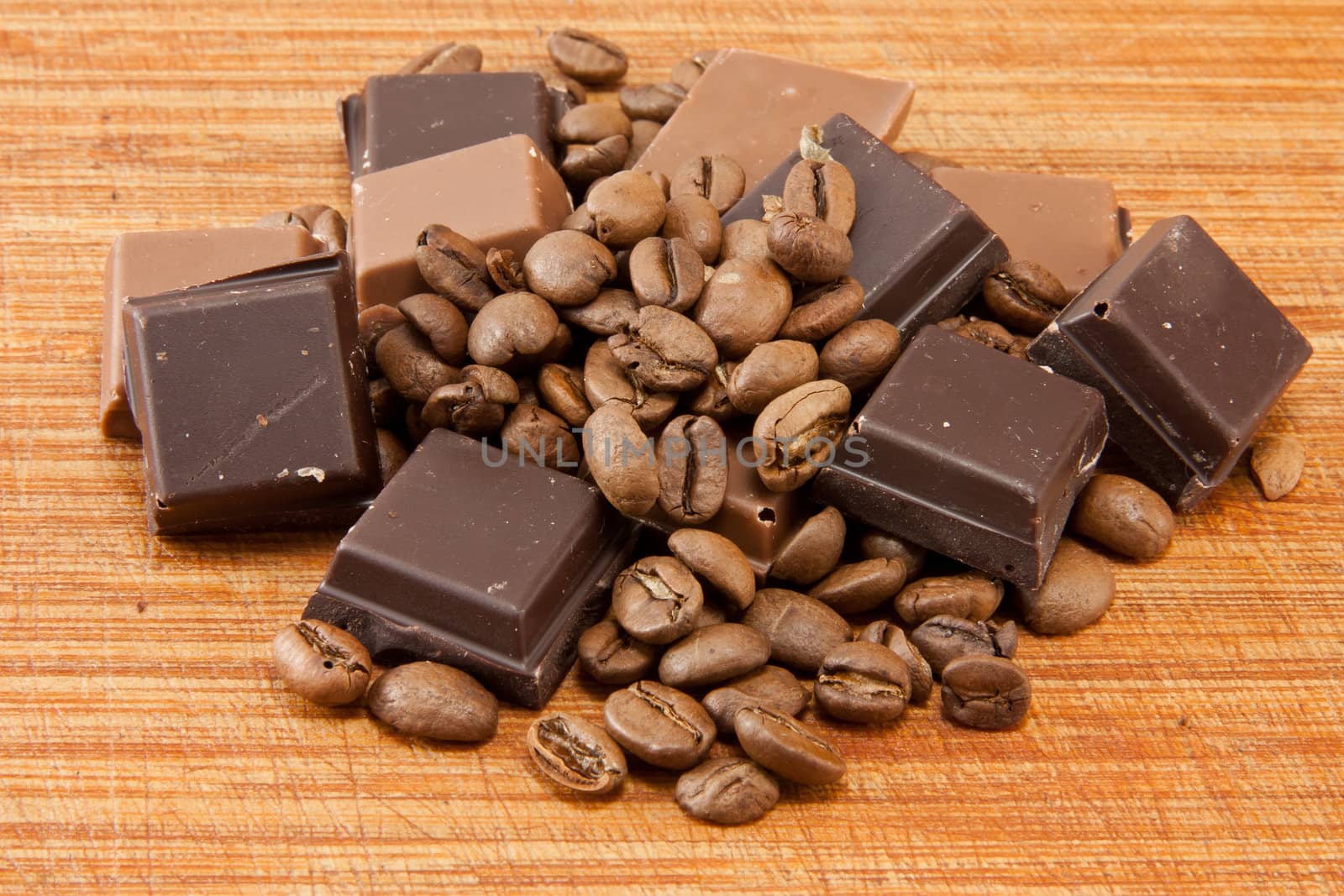 Picture of some coffee beans and chocolate on a wooden plate