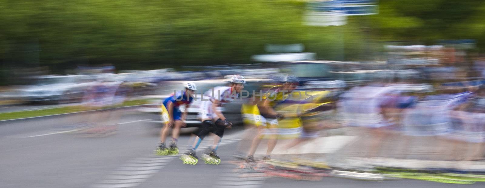 motion blur of skating men in a road race