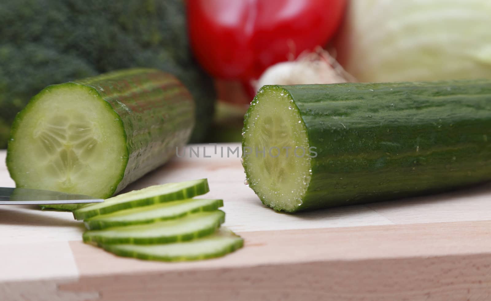 Close-up image of a sliced cucumber on a wooden choping board.Selective focus on the cucumber.