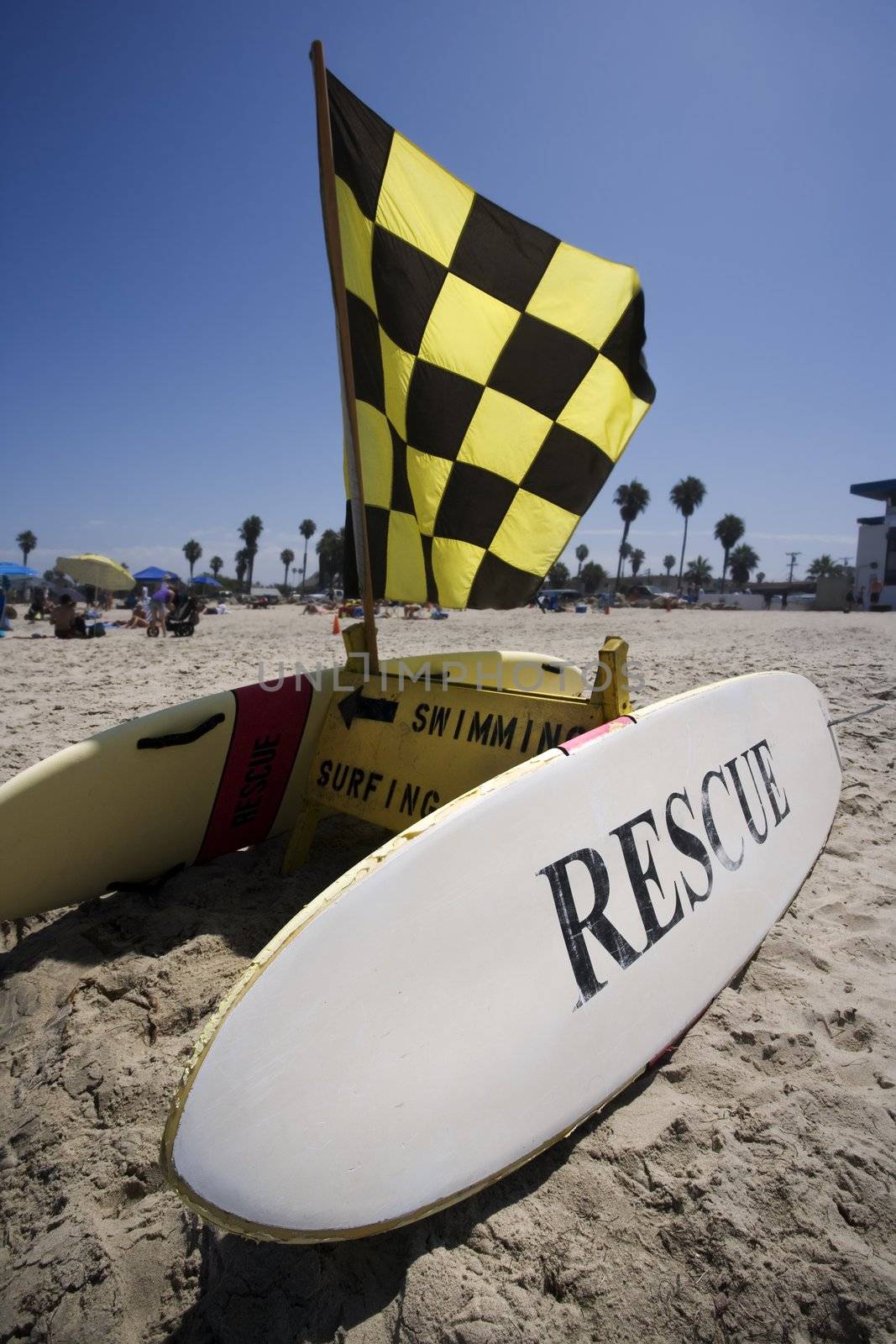 Rescue surfboard and warning flag on beach