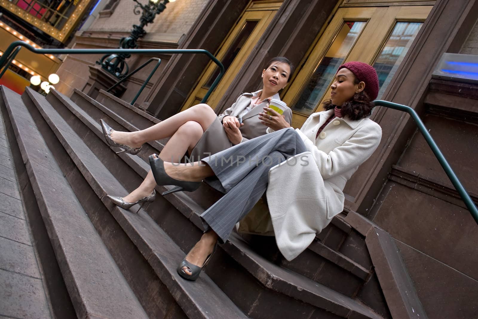 Two business women having a casual meeting or discussion in the city. 